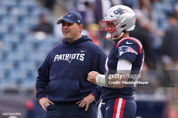 Mac Jones of the New England Patriots talks with Quarterbacks coach Joe Judge before the game against the Baltimore Ravens at Gillette Stadium on...