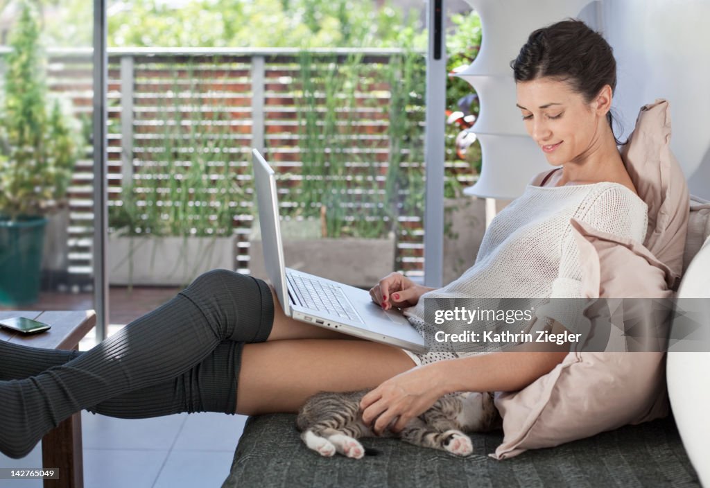 Woman relaxing on the sofa, holding laptop