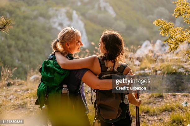 mother and daughter embracing after getting on top of the mountain - mom cheering stock pictures, royalty-free photos & images