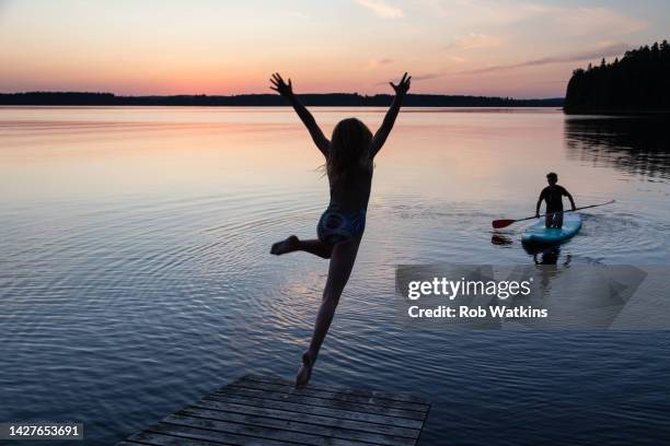 paddle boarding  teenagers  summerhouse lake sunset nordic - finland spring stock pictures, royalty-free photos & images