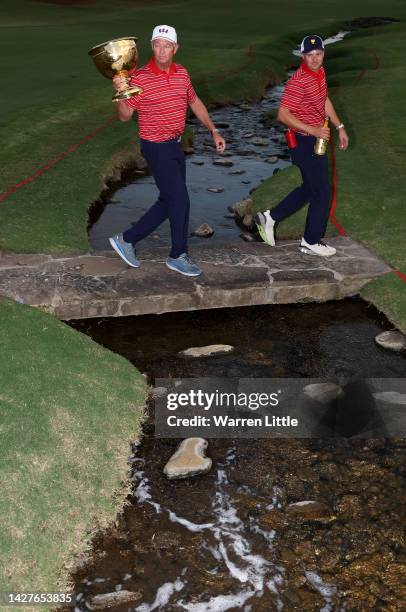 Captain Davis Love III and Jordan Spieth of the United States Team cross the bridge on the 15th green with the Presidents Cup at the closing ceremony...