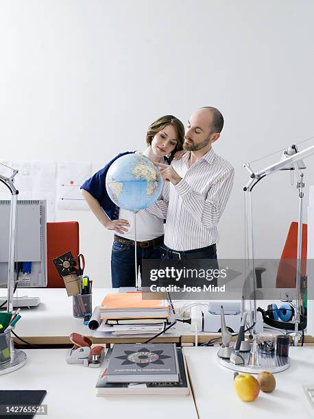 businescouple looking at globe - globe businessman stockfoto's en -beelden