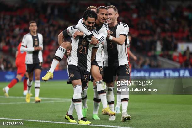 Ilkay Guendogan of Germany celebrates with teammates Leroy Sane and David Raum after scoring their side's first goal from the penalty spot during the...