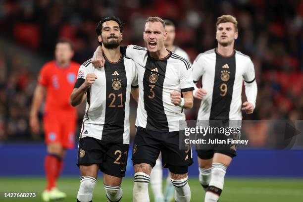 Ilkay Guendogan of Germany celebrates with teammate David Raum after scoring their side's first goal from the penalty spot during the UEFA Nations...