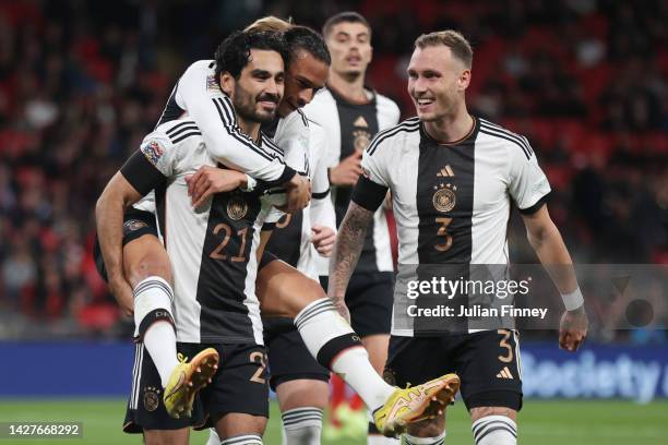 Ilkay Guendogan of Germany celebrates with teammates Leroy Sane and David Raum after scoring their side's first goal from the penalty spot during the...