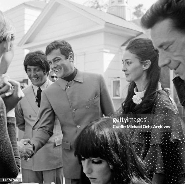 American actor Tony Curtis with his wife, actress Christine Kaufmann, circa 1965. Twiggy's manager Justin de Villeneuve is on the left.