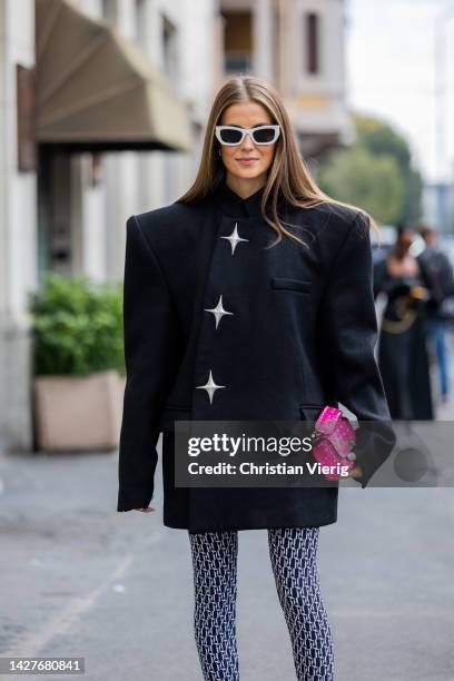 Nina Sandbech wears black oversized jacket with star print, leggings with logo print, platform shoes, pink micro Valentino bag outside Annakiki...