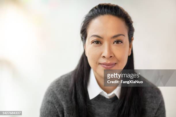 porträt einer multirassischen asiatischen hispanischen pazifik-insulanerin in einem modernen büro - ausdrucksstark stock-fotos und bilder