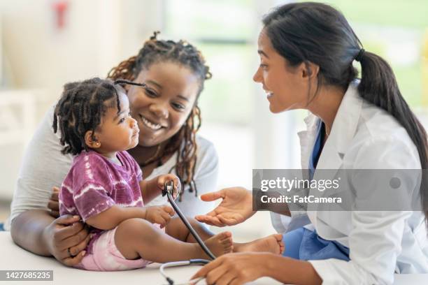 encuentro médico con una madre y su hijo - pediatrician fotografías e imágenes de stock