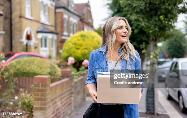 woman walking on the street carrying a package - woman hold box imagens e fotografias de stock