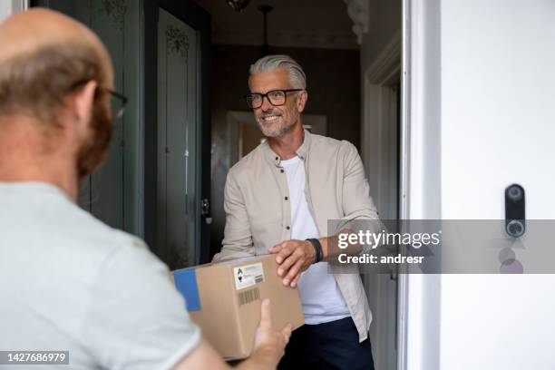 man getting a package delivered to his house - picking up mail stock pictures, royalty-free photos & images