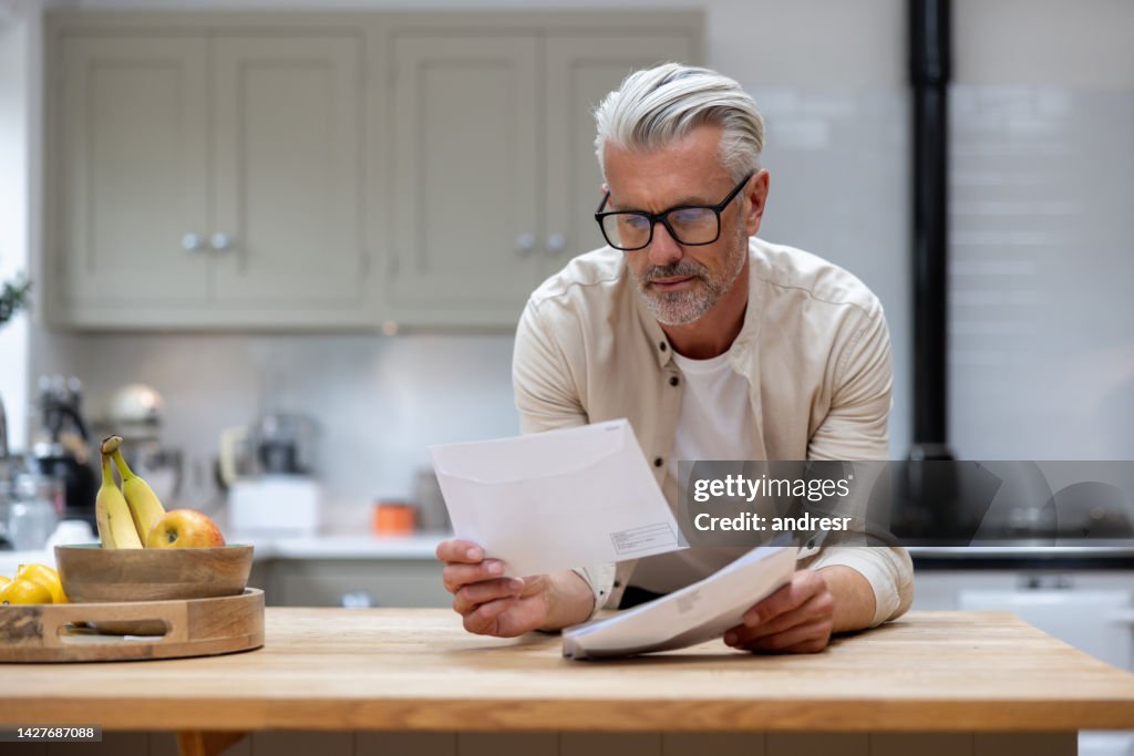 Mann zu Hause, der einen Brief in seiner Post liest