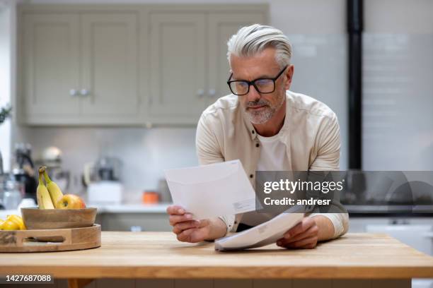 mann zu hause, der einen brief in seiner post liest - beautiful white kitchen stock-fotos und bilder