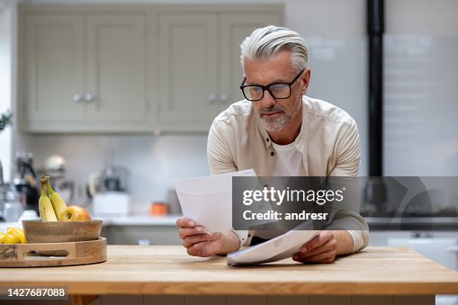 Man at home reading a letter in his mail Man at home reading a letter in his mail