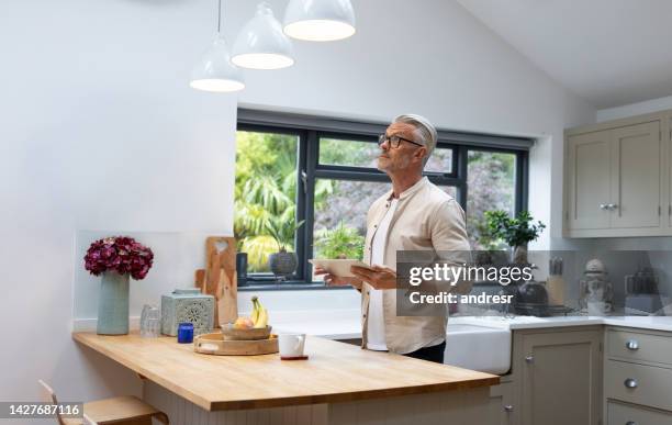 man controlling the lights in his house using an automated system - dimmer switch stock pictures, royalty-free photos & images