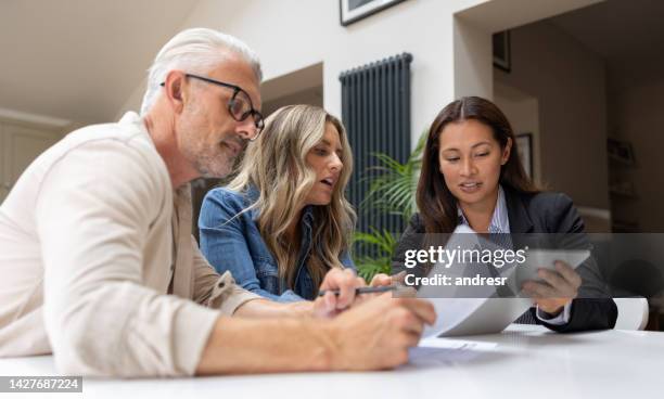 financial advisor talking to a couple about their options to buy a house - landlord stock pictures, royalty-free photos & images