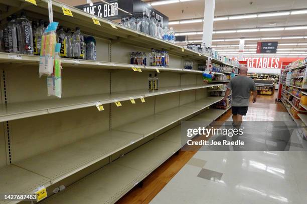 Person stands in an empty water aisle in a grocery store as people stock up on necessary items in prepartation for the possible arrival of Hurricane...