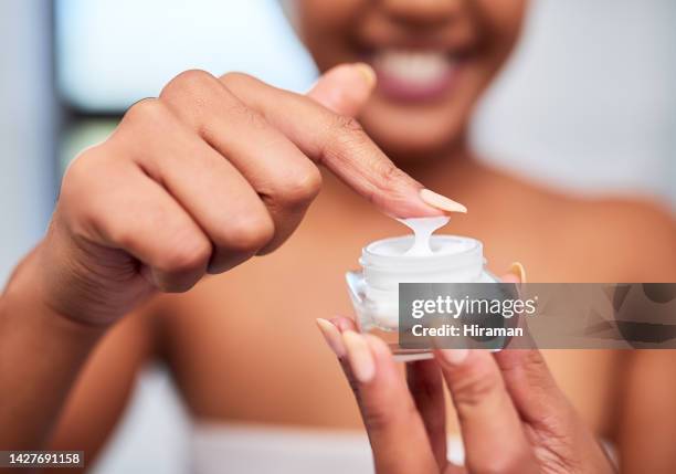 producto para el cuidado de la piel, dermatología y mujer negra con crema de belleza para un rostro sano, limpio y brillante. bienestar, manos y joven africana aplicando loción corporal en el dedo en el baño de cerca - hidratacion facial fotografías e imágenes de stock