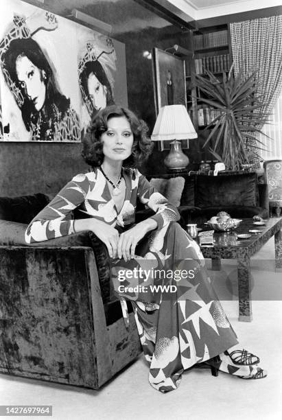 Model wears a Diane von Furstenberg seagull-printed wrap dress and poses in the designer's apartment. An Andy Warhol portrait of Diane von...