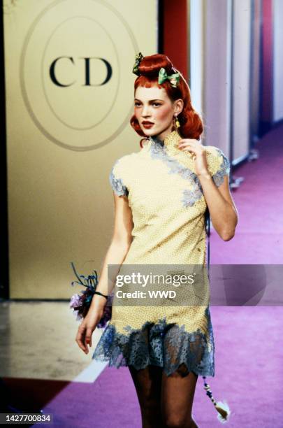 Model Kate Moss walks the runway in a lace trimmed qipao styled dress designed by John Galliano for Christian Dior's fall 1997collection.