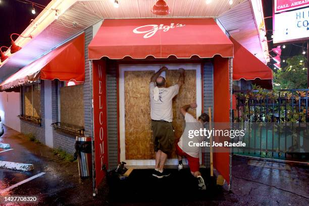 Steve Newberne and Richard Latronita board up Gigi's restaurant in preparation for Hurricane Ian on September 26, 2022 in St. Petersburg, Florida....