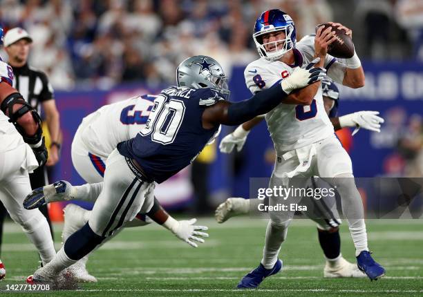 Daniel Jones of the New York Giants scrambles against DeMarcus Lawrence of the Dallas Cowboys during the second quarter in the game at MetLife...