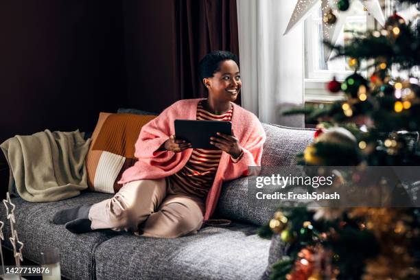 woman using a tablet device at home - ereader stockfoto's en -beelden