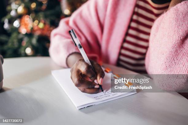 woman writing new year's resolutions - escrito à mão imagens e fotografias de stock