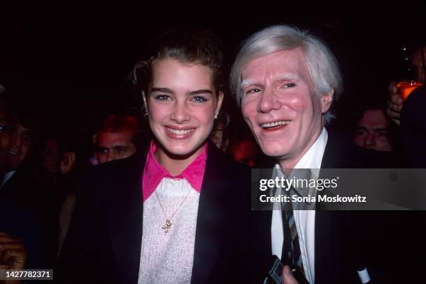 American actor and model Brooke Shields and artist Andy Warhol as they attend a party, to celebrate the publication of Warhol's book 'Exposures,' at...