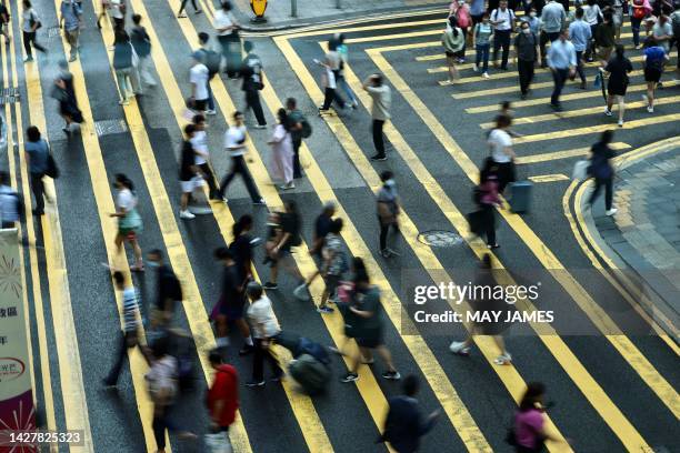 People cross a road in Central, a financial hub in Hong Kong on July 3, 2023.