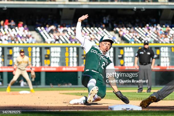 Yonathan Daza of the Colorado Rockies slides safely to third base on a sacrifice fly in the fifth inning of a game against the San Diego Padres at...