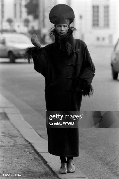 Model poses in a fur trim coat, sculptural toe shoes, hat and gloves from Pierre Cardin's fall 1985 couture collection advance shot on location in...