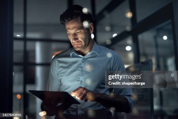 business man, working and tablet of a employee doing digital, web and internet strategy planning. corporate businessman and tech worker in the dark using technology to work on online and it analytics - artificial intelligence stockfoto's en -beelden