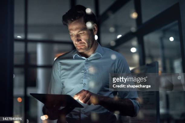 business man, working and tablet of a employee doing digital, web and internet strategy planning. corporate businessman and tech worker in the dark using technology to work on online and it analytics - fintech stock pictures, royalty-free photos & images