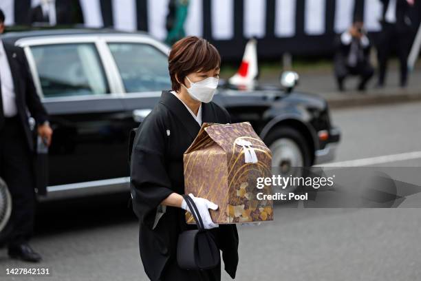 Akie Abe, wife of former Prime Minister Sinzo Abe, carries his ashes in an urn as she arrives for the state funeral for Japan's former prime minister...