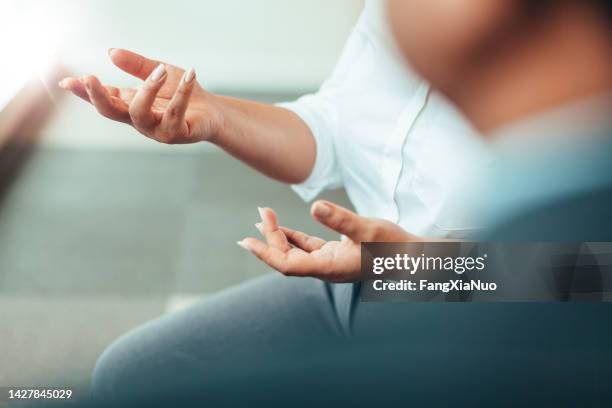 mani di una donna d'affari afro-americana asiatica che parla discutendo in una riunione in una clinica di terapia d'ufficio aziendale in abbigliamento da lavoro - gesto con la mano foto e immagini stock