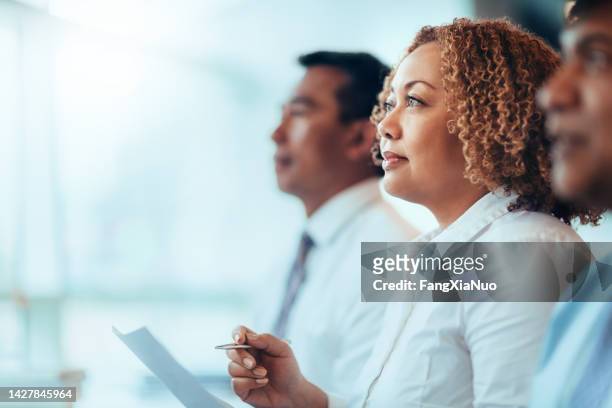 japanese african-american mature businesswoman student sitting learning listening in education training seminar meeting in business office classroom with multiracial colleagues - meek mill supporters protest on day of status hearing stockfoto's en -beelden