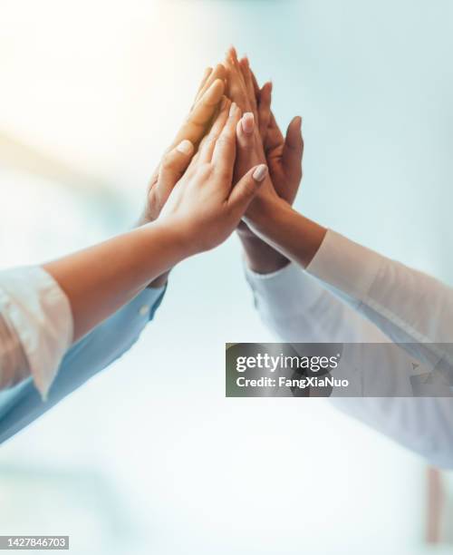 multiracial group of students stacked hands high-five in agreement achievement success aspiration smiling in bright business office classroom - hands at work imagens e fotografias de stock