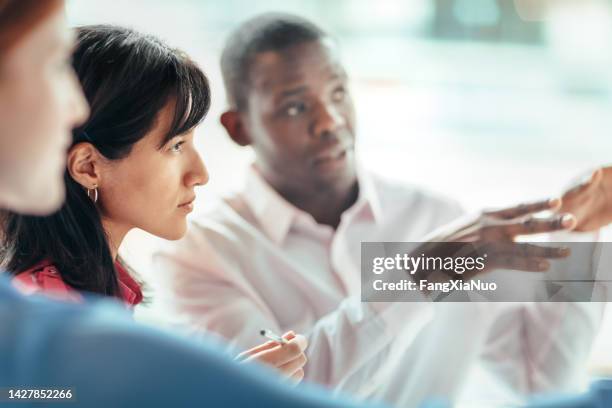 hispanic mid adult woman collaborates thinking contemplation serious with multiracial work colleagues students in business office learning education brainstorming ideas - market research stock pictures, royalty-free photos & images