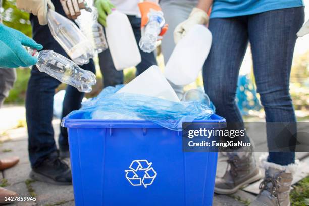 group of volunteers with youth organization charity help cleanup recycle plastic bottles into recycle bin in local public park in residential neighborhood together - mixed recycling bin stock pictures, royalty-free photos & images
