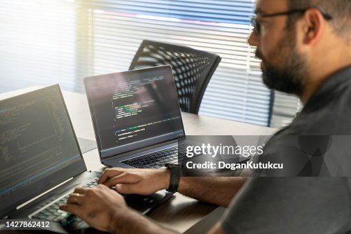 Programmer writing code on laptop Programmer writing code on laptop