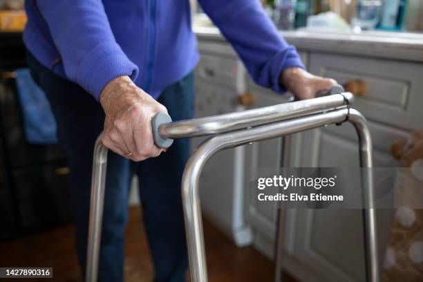 close up of the hands of a senior woman walking with the use of a walking frame. - lentezza foto e immagini stock
