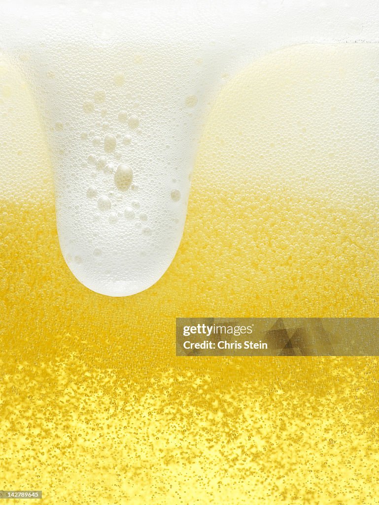 Glass of overflowing beer foam