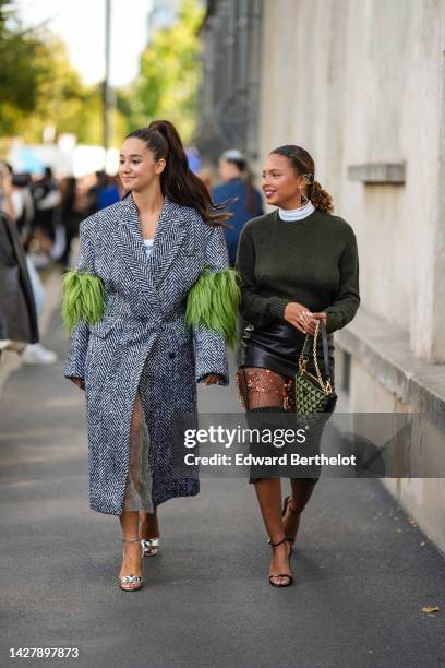 Lena Mahfouf aka Lena Situations wears a black and white striped print pattern oversized long coat with embroidered green fringed sleeves, silver...