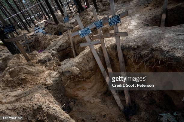 Silence, makeshift crosses, and open graves are all that remain after Ukrainian forensic and war crimes investigators complete their exhumation of...