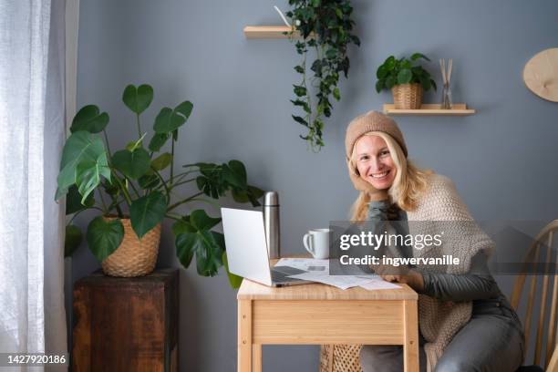 woman in woolen hat paying bills - saving electricity stock pictures, royalty-free photos & images