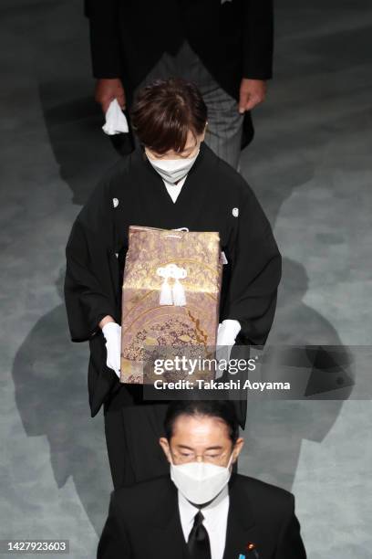 Widow of former Japanese prime minister Shinzo Abe, Akie Abe carries her husbands ashes behind Japan's Prime Minister, Fumio Kishida, during the...