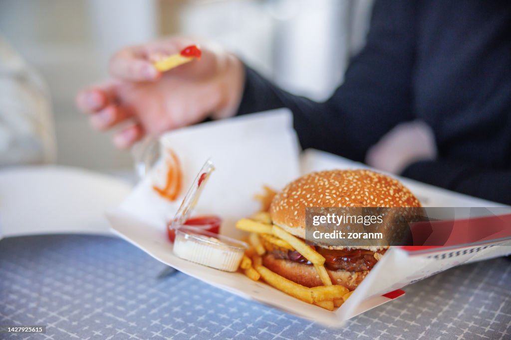 Burger and fries with dips on cardboard box delivered at home