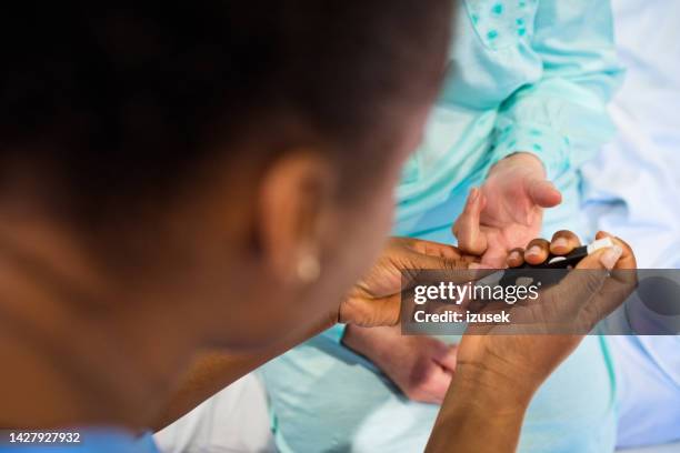 nurse doing blood sugar test on patient - glucose stock pictures, royalty-free photos & images