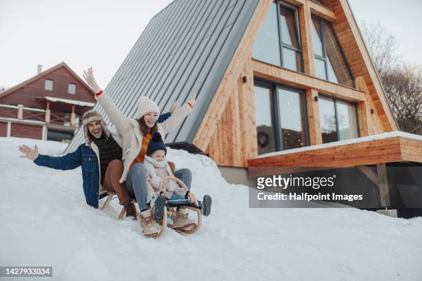 young family enjoying winter, sledging together. - ski resort 個照片及圖片檔
